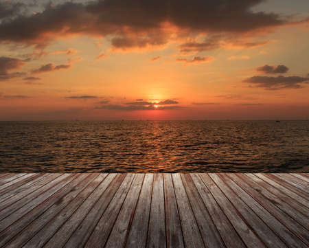 Wooden Floor under cloudy sky with sea at sunsetの写真素材