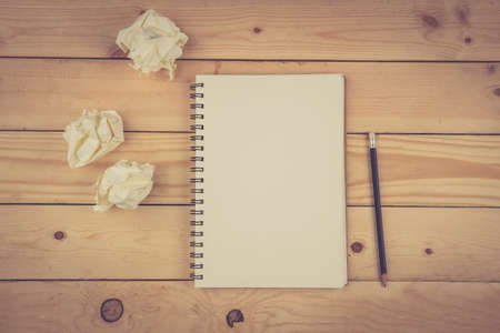 notebook and Crumpled paper on wooden deskの写真素材