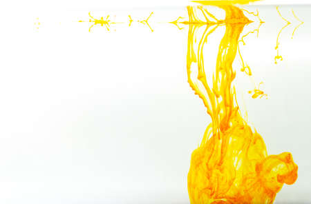 Yellow ink swirling in water, Color drop in water photographed in motionの写真素材