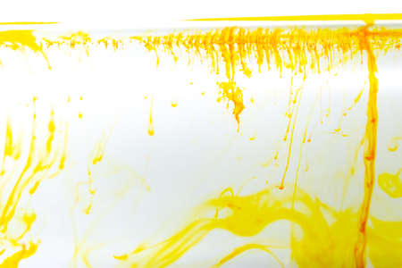 Yellow ink swirling in water, Color drop in water photographed in motionの写真素材