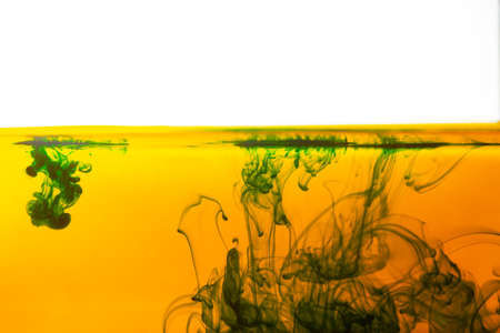 Ink in water splashing green yellow color background