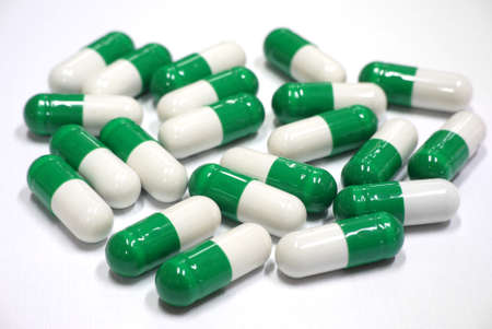 green and white capsules on white background
