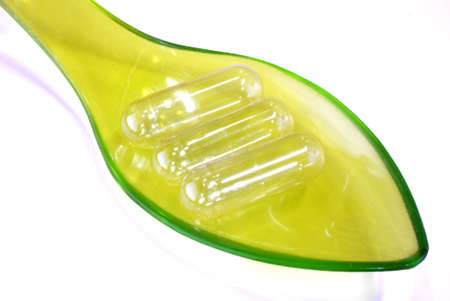empty capsules on green plastic spoonの写真素材