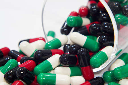 Red black and Green white capsules with a grass cupの写真素材