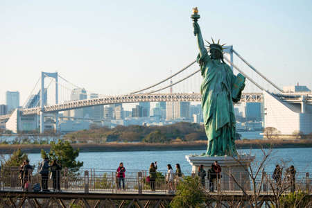 Tokyo, Japan - Mar 22, 2016 : Unidentified people at an elevated walkway in Odaiba visiting the view of  The Statue of Liberty and the Rainbow Bridge.のeditorial素材