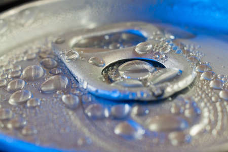 pop cans with drops of water closeup in blue light