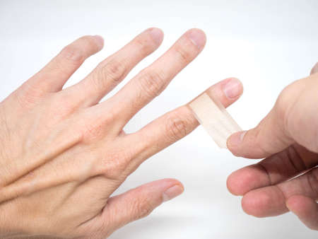Adhesive Healing plaster on asian man finger for first aid conceptの写真素材