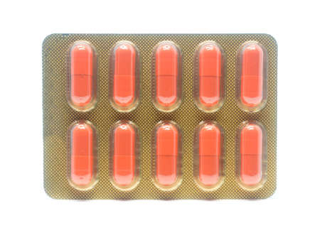 orange color gelatin capsules pills in blister pack isolated on white background.の写真素材