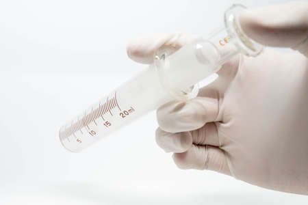 Old syringe medical equipment on hand with examination gloveの写真素材