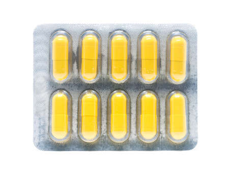 yellow gelatin capsules pills in blister pack isolated on white background.の写真素材