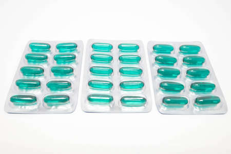 green soft gel capsules pills in blister pack isolated on white background.の写真素材