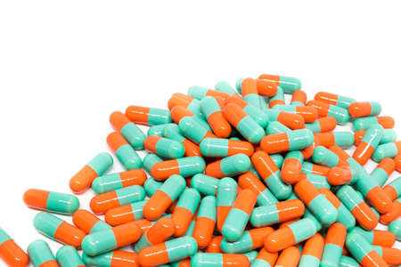 green orange color pills capsule on white background