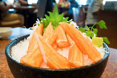 "Surimi" is japanese crab stick sashimi on ice in a black bowlの写真素材
