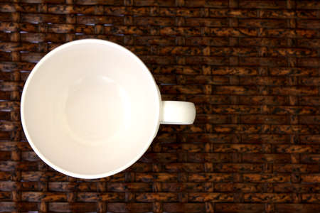 White cup placed on weave wood table