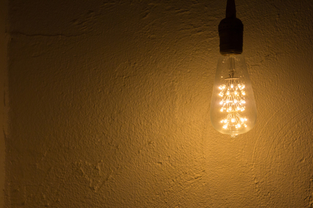 Lightbulb hang on white concrete wallの写真素材