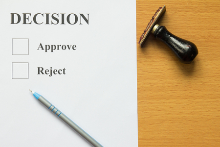 Decision paper with blue pen and rubber stampの写真素材