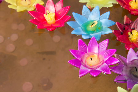 Colorful candle in lotus shape floating on waterの写真素材