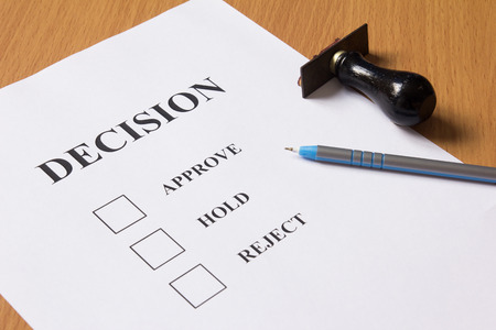 Decision paper (approve, hold, reject) with pen, rubber stampの写真素材