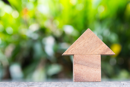Wooden toy as dream house concept with blurred green backgroundの写真素材