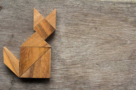 Wooden tangram as cat shape on old wood backgroundの写真素材