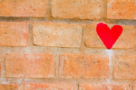 Red heart draw on brown brick wall backgroundの写真素材