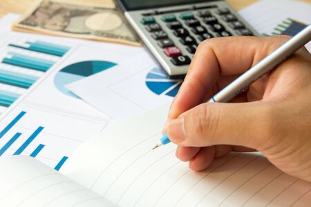 Blank note book with financial graph, calculator and japanese yen banknoteの写真素材
