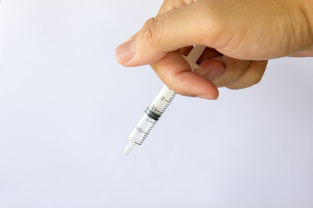 Man hold the plastic syringe on white backgroundの写真素材