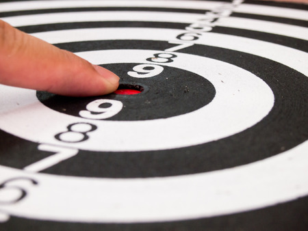 Black and white dart with hand point at center (Concept for target, achievement, business focus)の写真素材