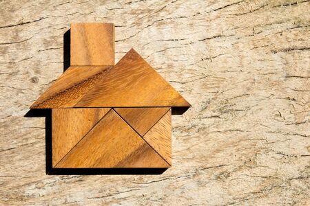 Wooden tangram puzzle in home shape for dream home or happy life conceptの写真素材