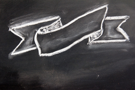 Blank ribbon draw by white chalk on black board backgroundの写真素材