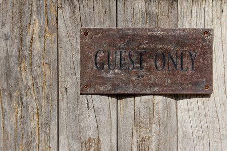Rust plate with Guest only wording on wooden backgroundの写真素材