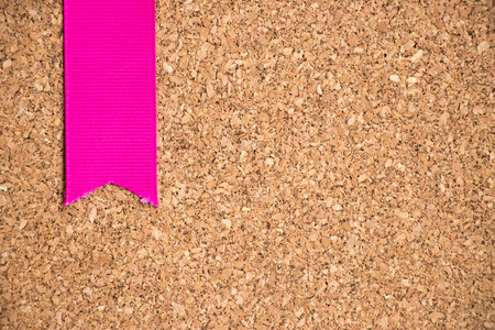 Pink ribbon on cork board texture backgroundの写真素材