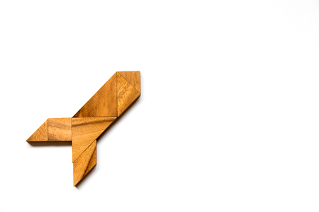 Wooden tangram puzzle in rocket shape on white background (Concept for new experience, start project)の写真素材