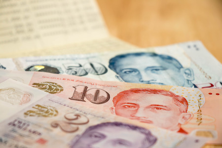 Bank passbook with Singapore dollar on wood table backgroundの写真素材