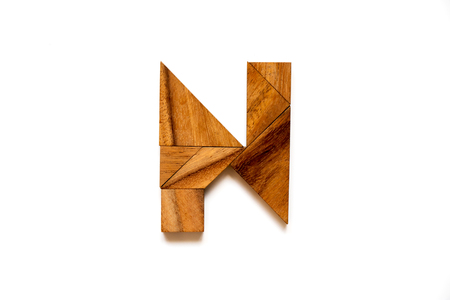 Wooden tangram puzzle as English alphabet letter "N" shape on white backgroundの写真素材