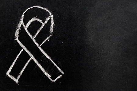 White chalk drawing as black ribbon shape on black board background (Concept for symbol of remembrance or mourning)の写真素材