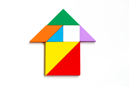 Color wood tangram puzzle on arrow or house shape on white backgroundの写真素材