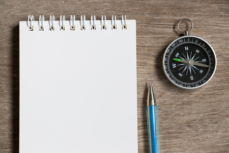 Blank note paper with compass on wood desk backgroundの写真素材