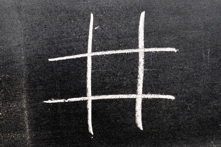 White color chalk hand drawing as hashtag shape on blackboard backgroungの写真素材