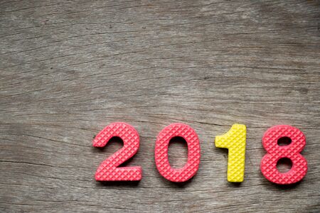 Toy foam alphabet in wording 2018 on wood background (Concept for Happy new year decoration)