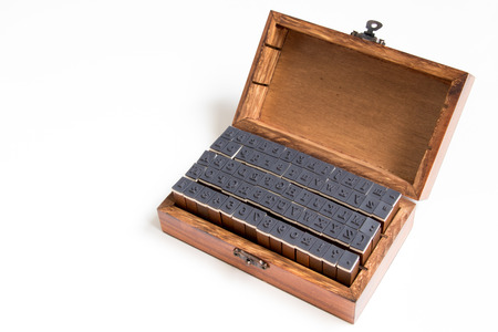 Wood box contain english alphabet and number rubber stamp on white backgroundの写真素材