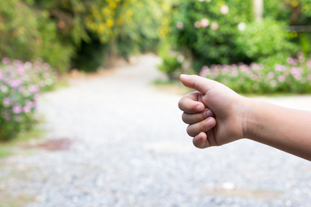 Asian boy show thumb up with blurred way background (Concept for hitch hiking, good work, like)の写真素材