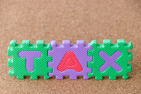 Colorful toy foam alphabet in word tax on cork board backgroundの写真素材