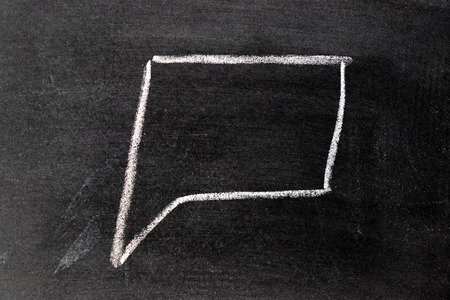 White chalk hand drawing in square bubble speech shape with blank space on blackboard backgroundの写真素材