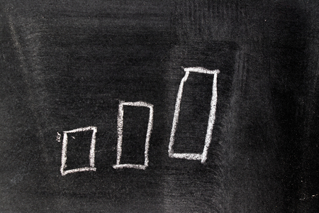 White chalk hand drawing in uptrend barchart  shape on blackboard backgroundの写真素材