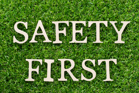 Wood alphabet in word safety first on artificial green grass backgroundの写真素材