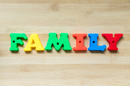 Color plastic alphabet in word family on wood backgroundの写真素材