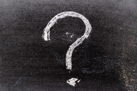 White color chak hand drawing in question mark shape on blackboard background