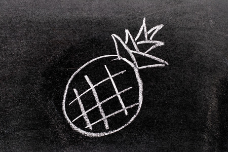 White color chalk hand drawing in pineapple shape on blackboard backgroundの写真素材