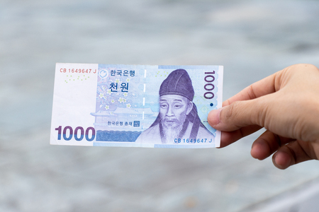 Man hold south korea banknote 1000 won on blurred backgroundの写真素材